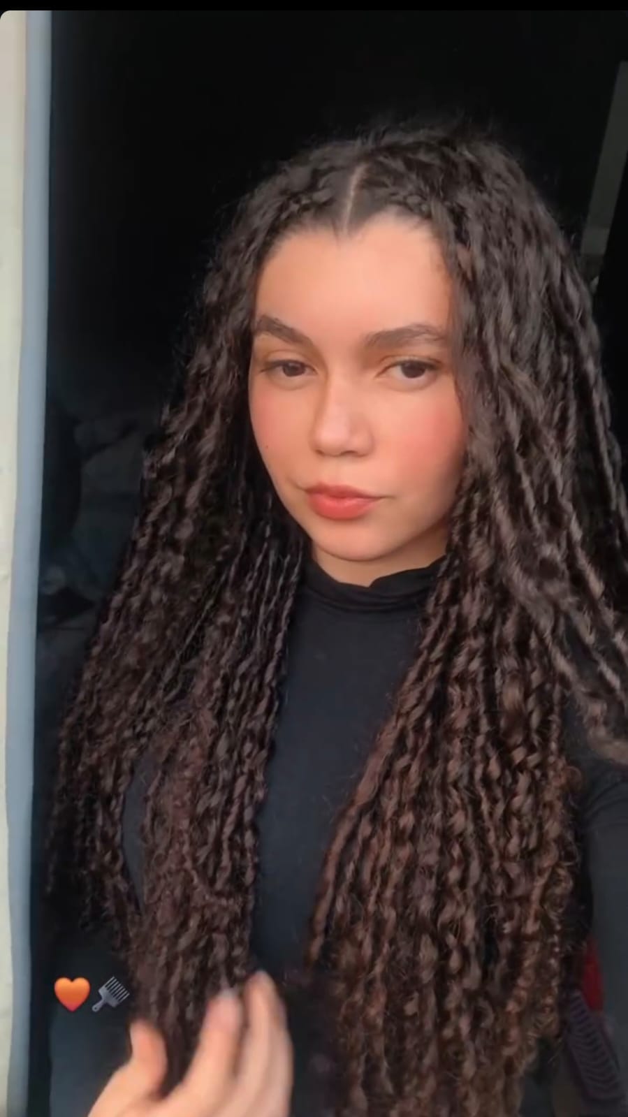 Ela com suas tranças e blusa preta
